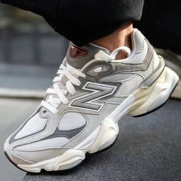 Gray and white sneaker with brand logo on a blurred background