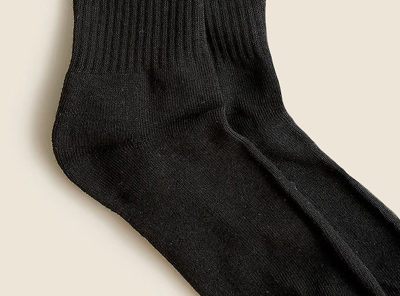 Close-up of a black sock on a beige background