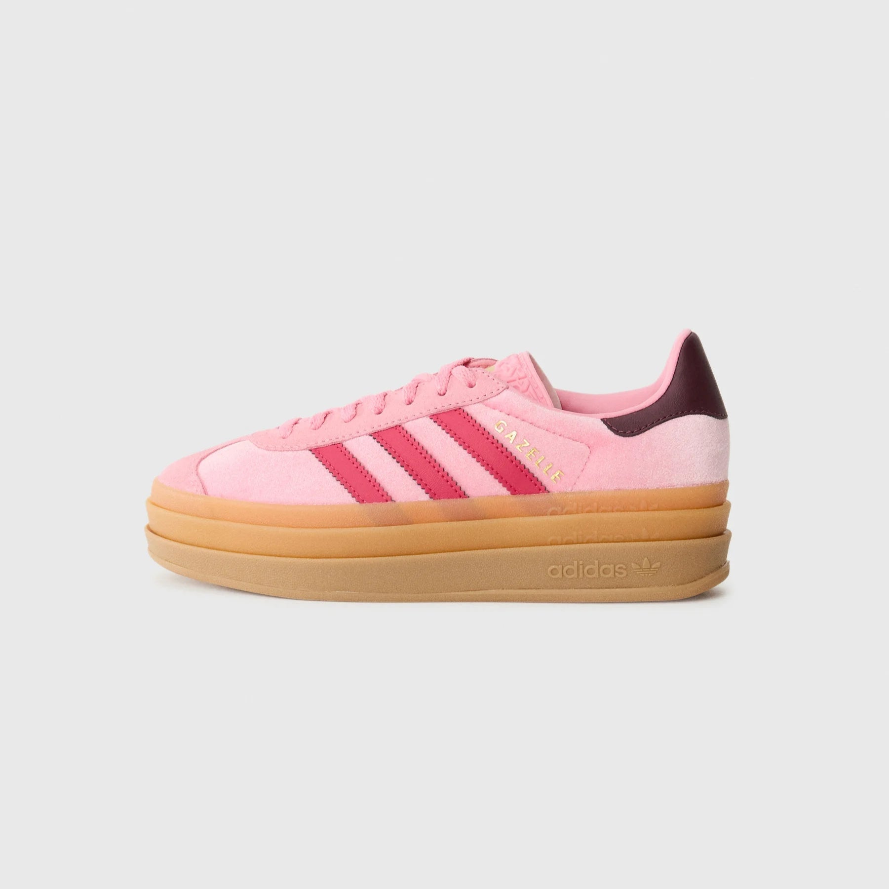 Pink Adidas sneaker with a brown sole on a light gray background