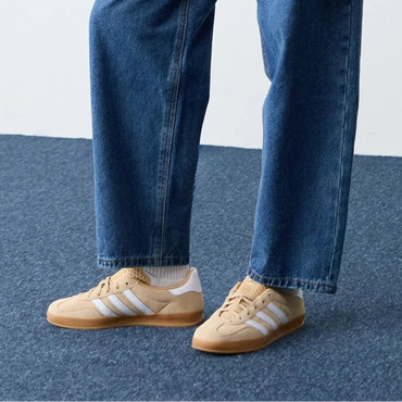 Person wearing a blue denim jacket and jeans on a white background