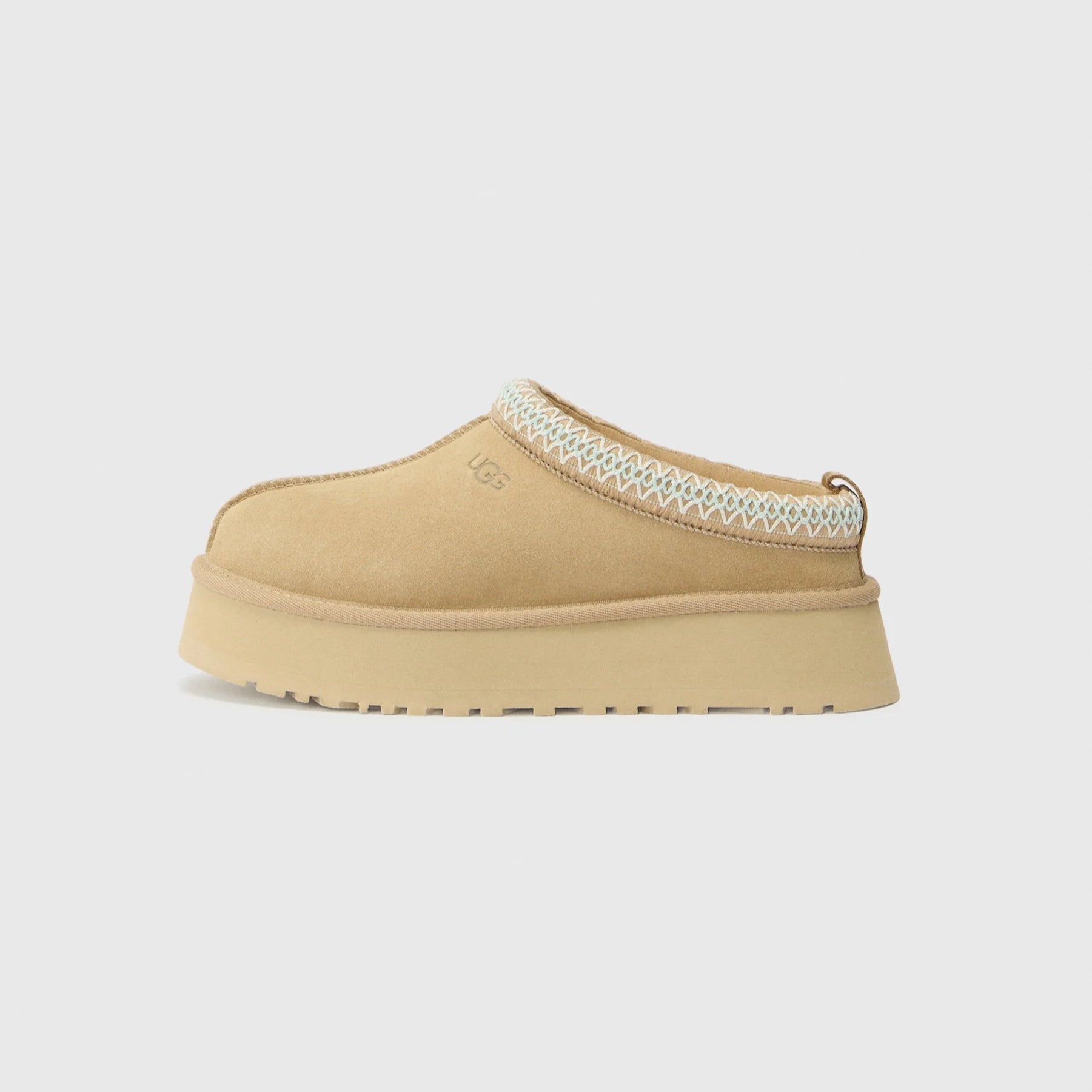Beige slip-on shoe with a textured strap on a light gray background
