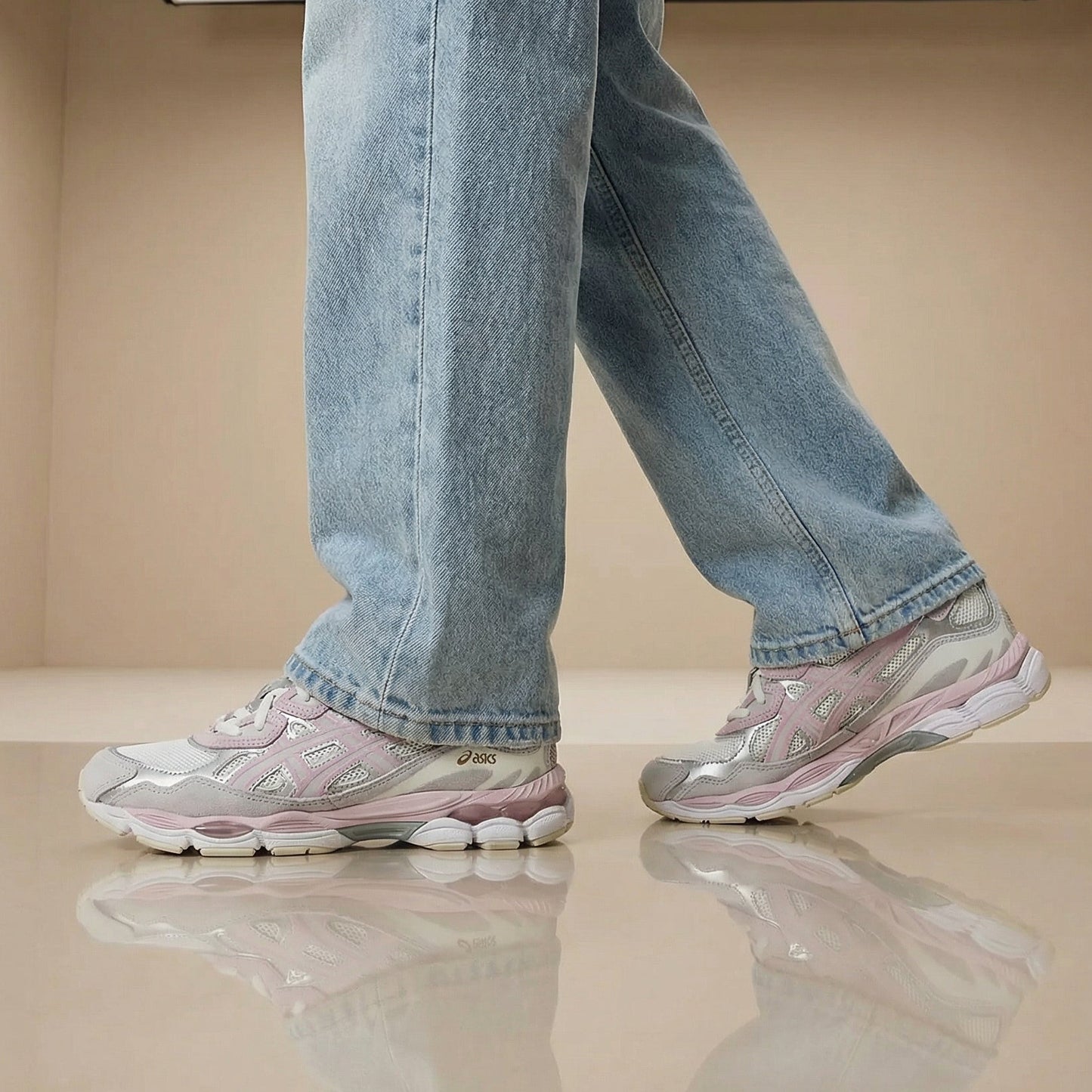 Person wearing blue jeans and pink sneakers in a minimal indoor setting